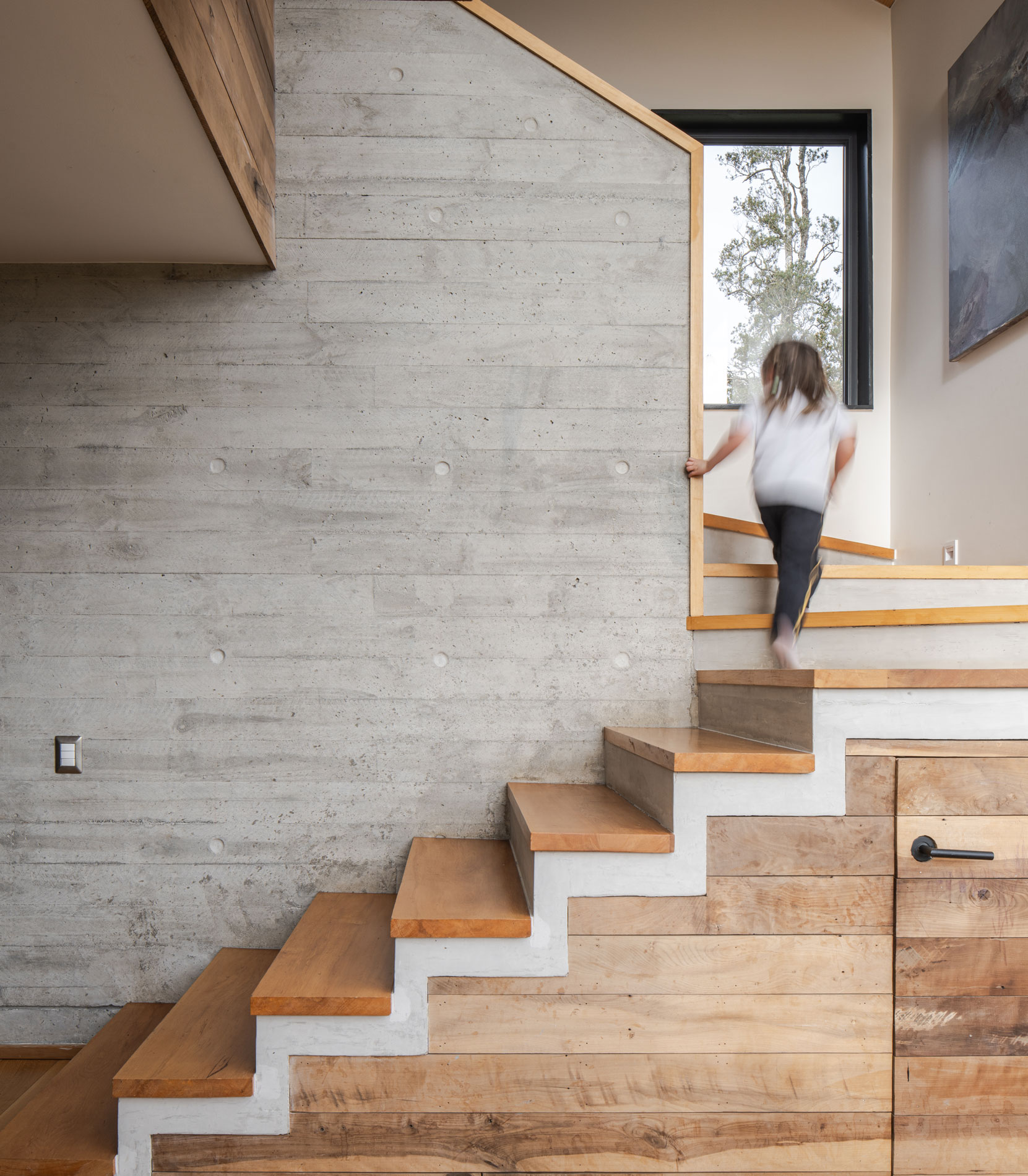 Escalera de hormigón y madera en dos tramos. Abierta a la sala de estar familiar. Casa Carpintero. LAGAR arqtos.