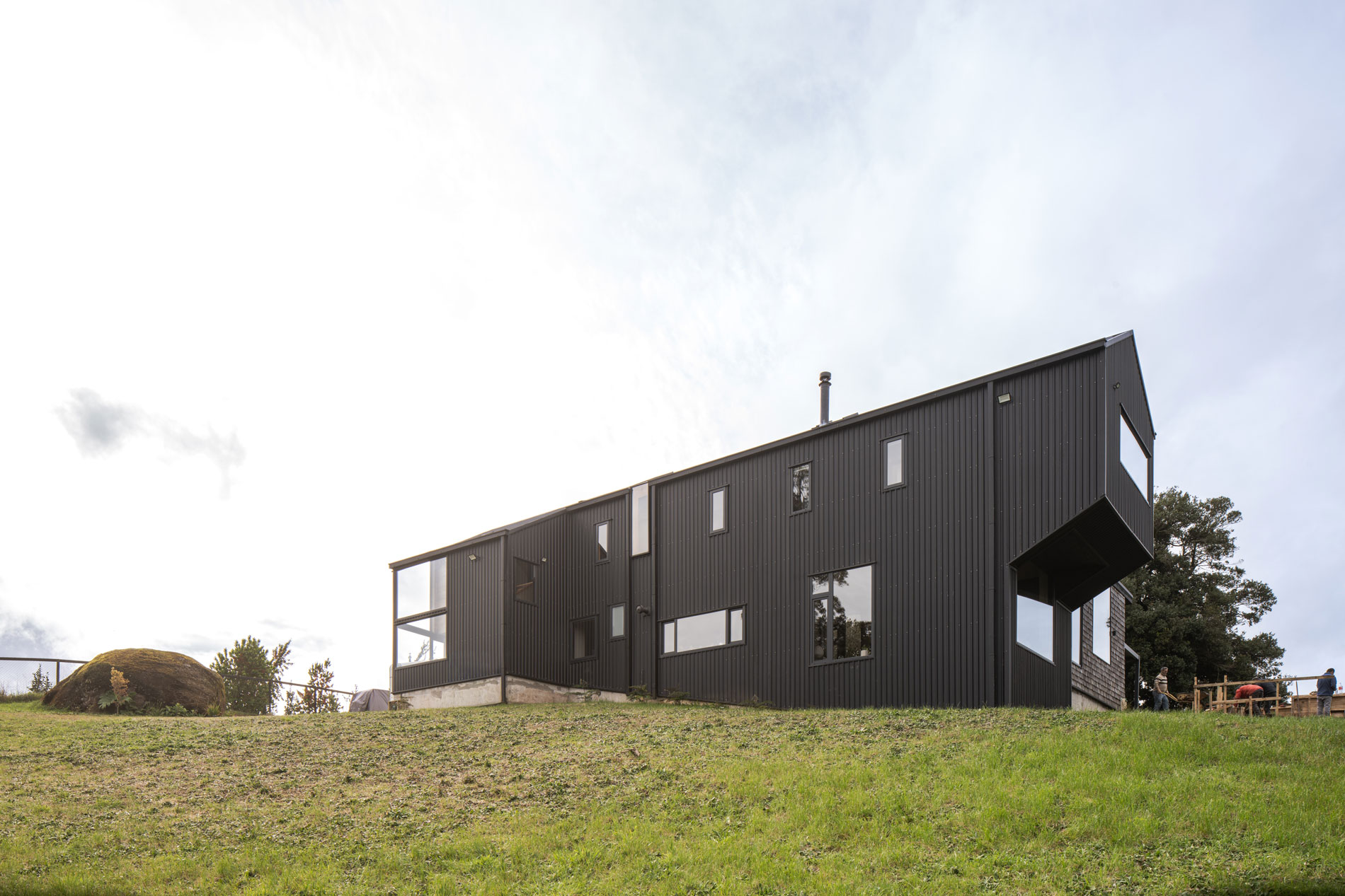Fachada Sur protegida por revestimiento acanalado metálico, ideal para el viento y la lluvia de sur. Casa Carpintero. LAGAR arqtos.