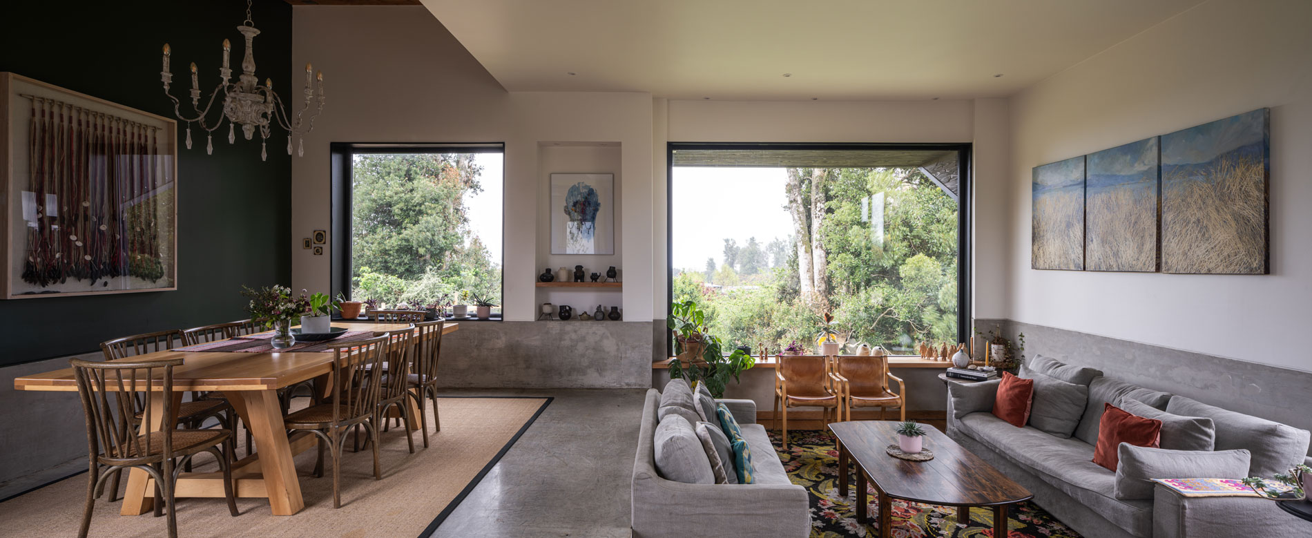 Living y comedor familiar, con grandes ventanas al bosque nativo del sur de Chile. Casa Carpintero. LAGAR arqtos.