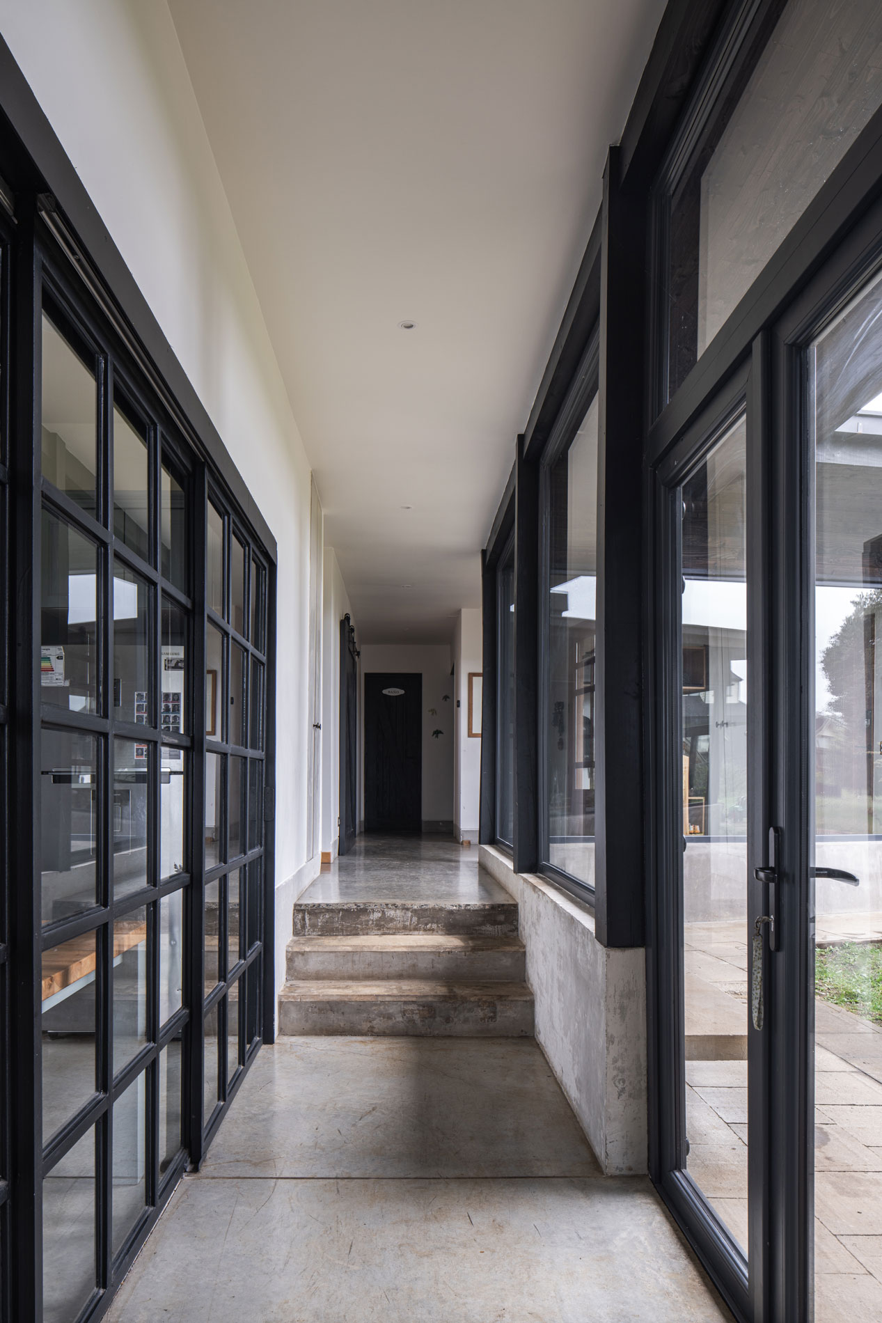 Pasillo principal con transparencias al paisaje y la cocina. Conecta el acceso, la escalera y los espacios familiares. Casa Carpintero. LAGAR arqtos.